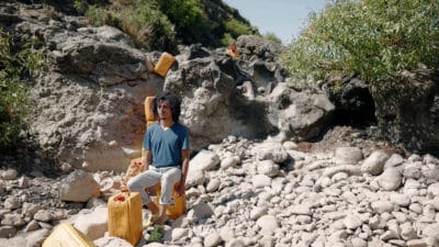 Photo of Dawit Seto Gobeze sat amongst some beach rocks