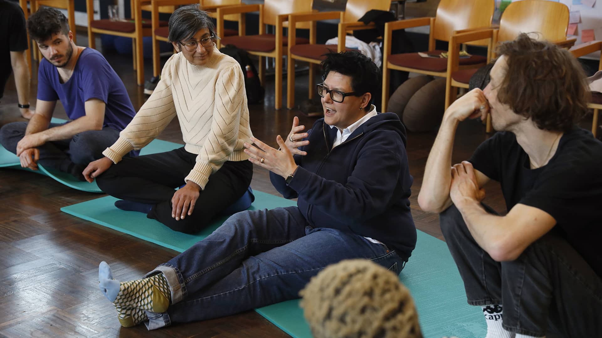 People sat down on mats engaging in conversation